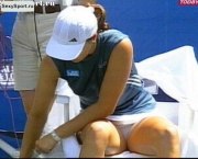Теннисистка сидит на стуле и показывает трусы между ног
